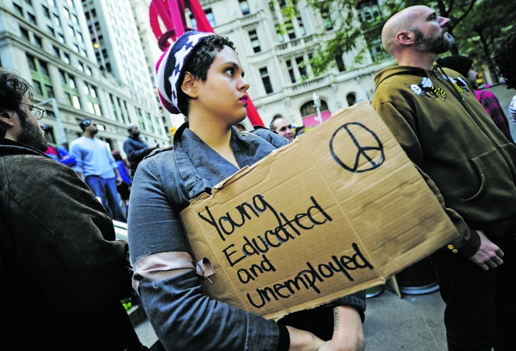 Protester holding a sign saying Young, Educated and Unemployed.