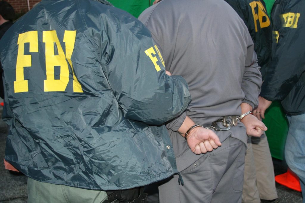 Senators to Consider New FBI Chief FBI Agents take away a criminal in handcuffs.