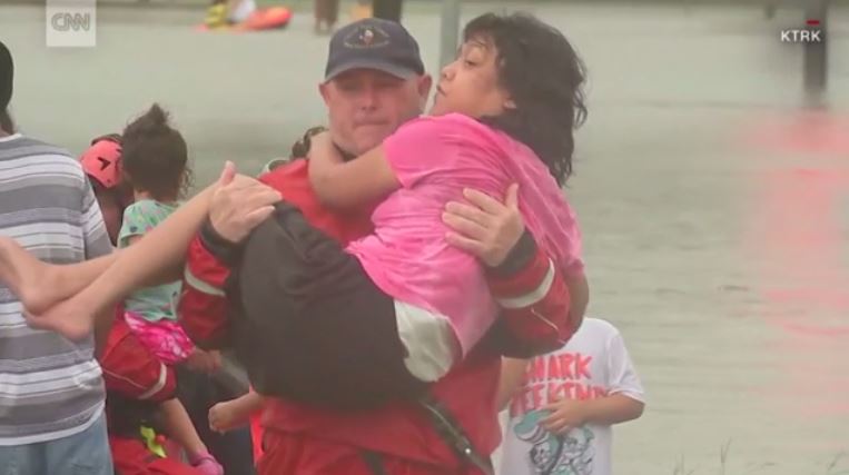 A man rescues a woman from the flooding in Houston.