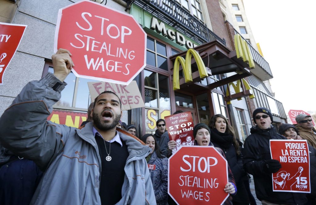 Protesters hold signs saying 'Stop Stealing Wages