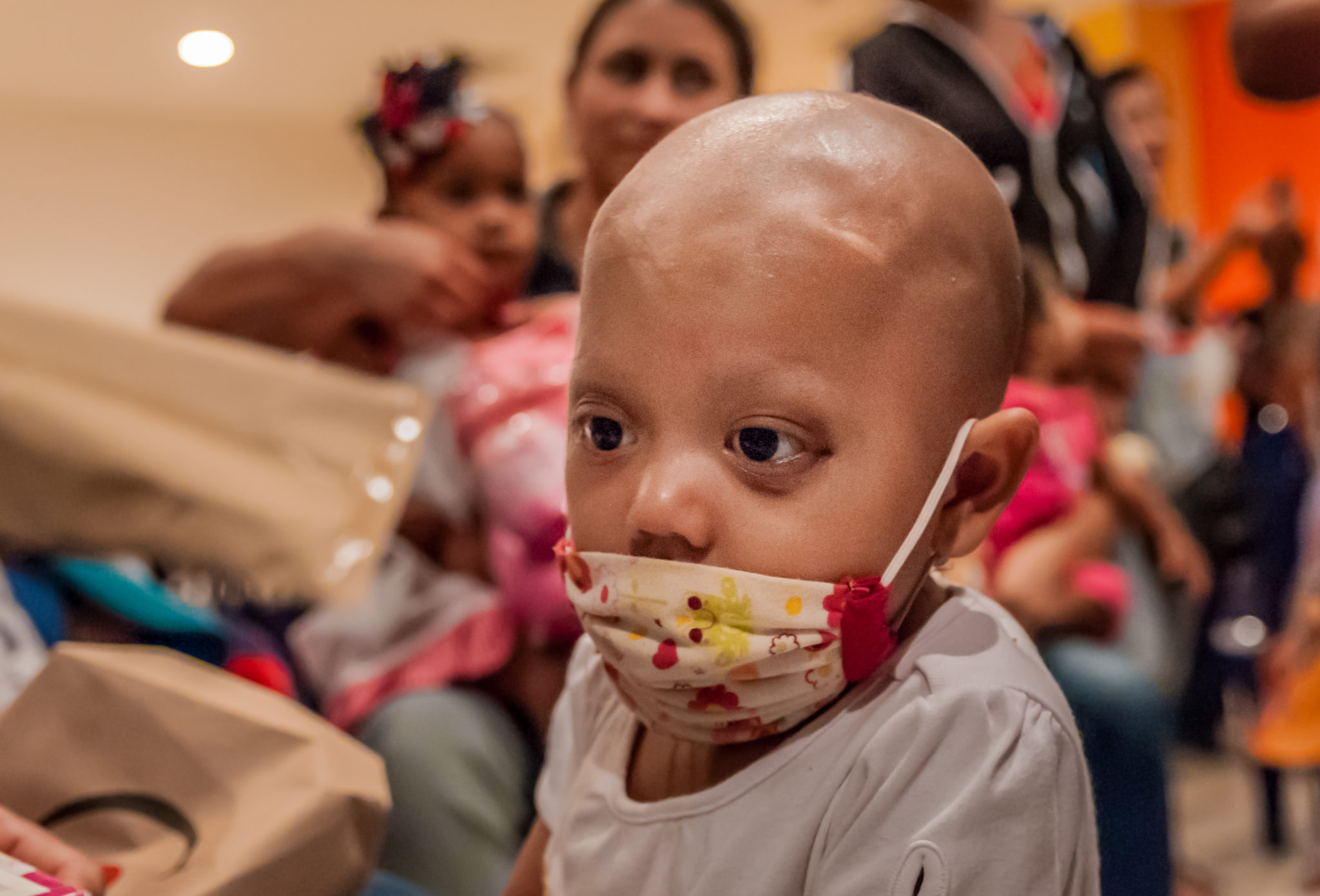 A child with cancer wearing a surgical mask.