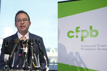 Mick Mulvaney Speaks in front of a CFPB sign