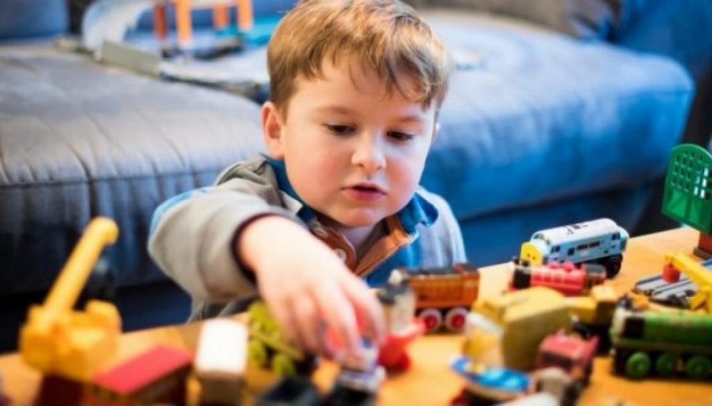 A young boy plays with toys.