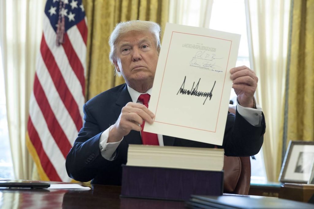 President Trump Holds up the signature on his 1.5 trillion dollar tax plan.