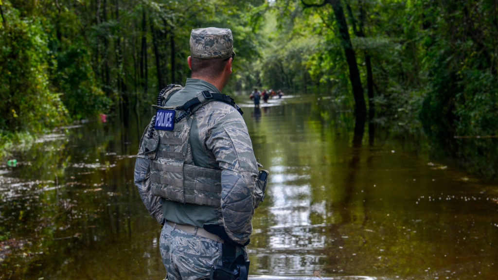 An Air Force Security Forces Airman watches waters rise in South Carolina as the White House ignores latest warning on climate change
