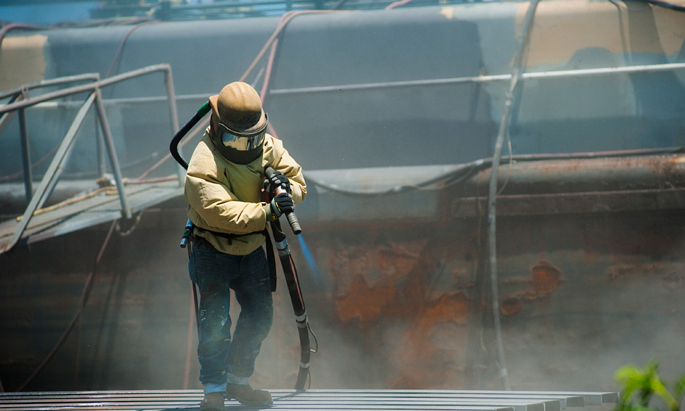 Worker using industrial Sand Blaster