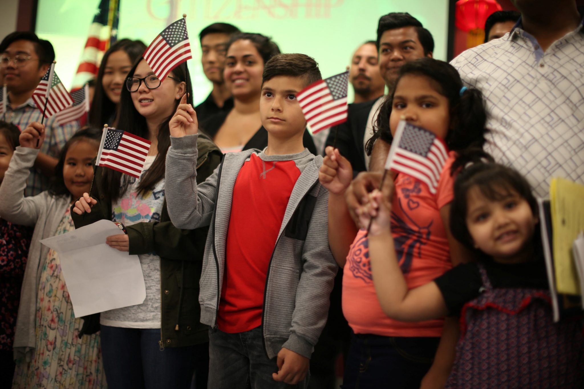 Children say the pledge of allegiance during a ceremony to present citizenship certificates to young people who earned citizenship through their parents, in Los Angeles, California