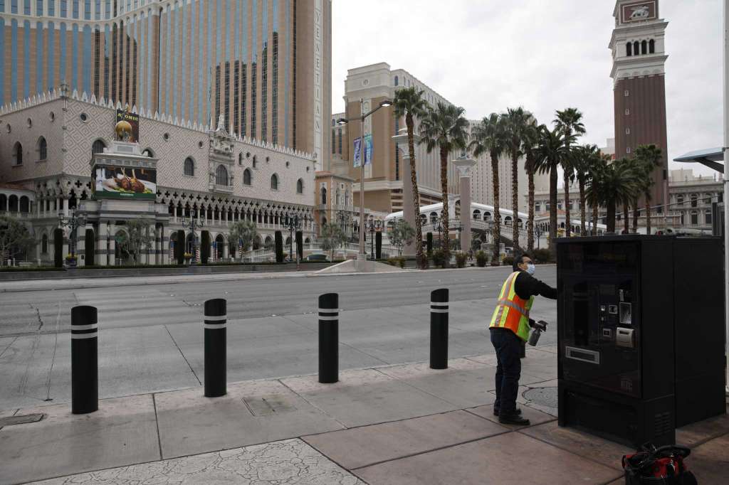 A worker in a mask cleans as people avoid the Las Vegas Strip after casinos have been ordered to shut down due to the coronavirus.