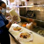Restaraunt worker preparing food.