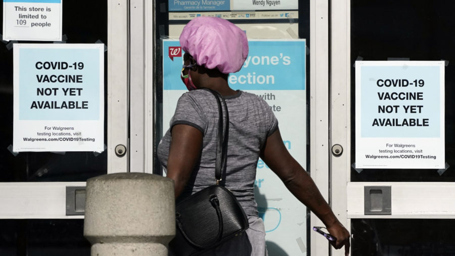 2020: A customer walks past a sign indicating that a COVID-19 vaccine is not yet available at Walgreens, Wednesday, Dec. 2, 2020, in Long Beach, Calif. (AP Photo/Ashley Landis)