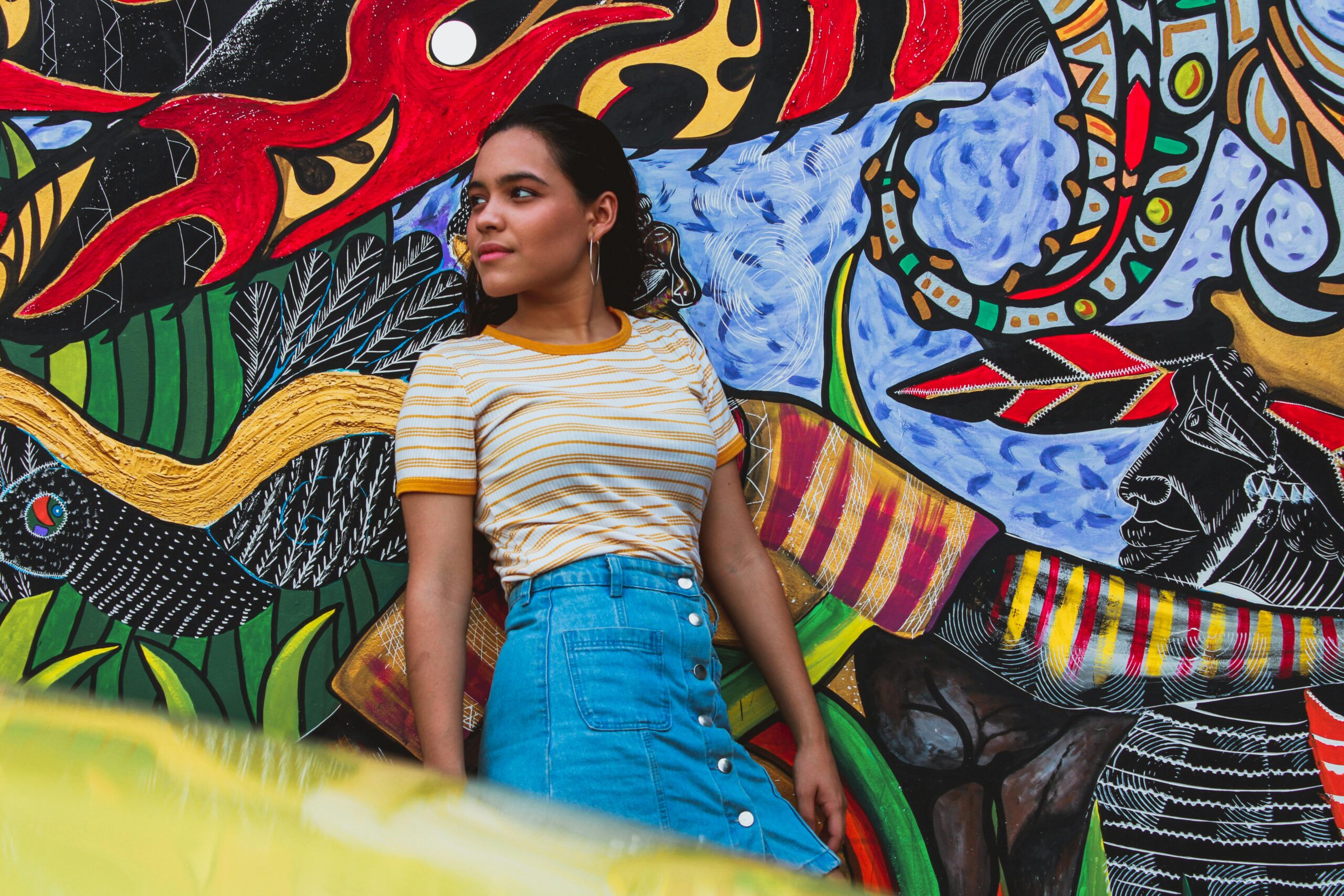 Latina in front of mural