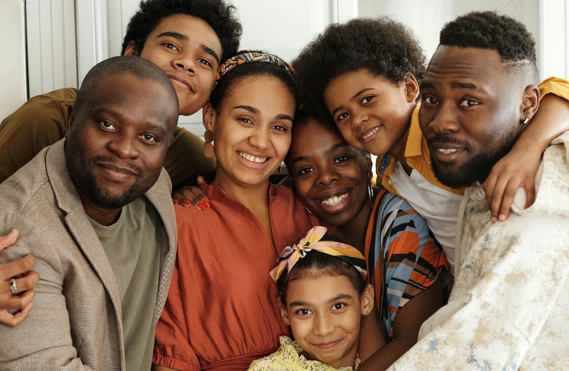 A diverse family group smiling warmly while gathered closely together, showcasing unity, love, and connection.