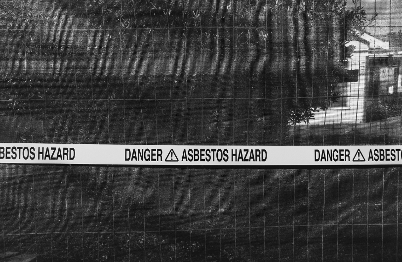 Emergency tape saying "danger asbestos hazard".