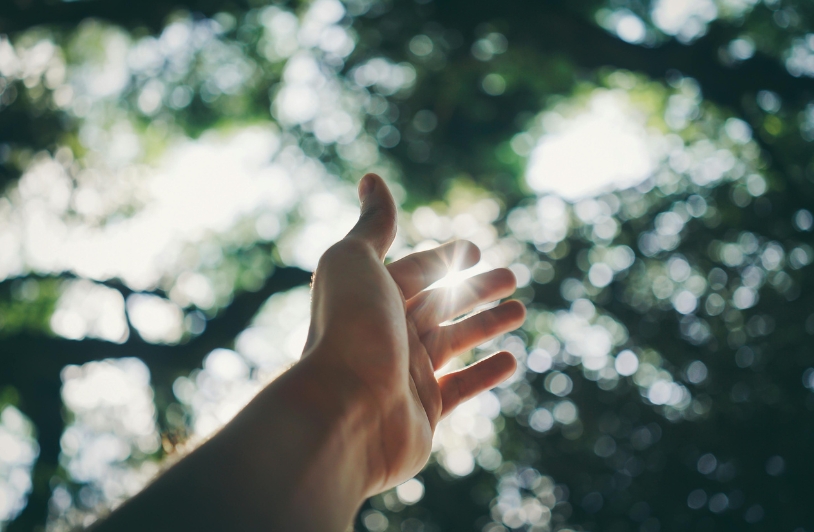 The Importance of Sunlight for Mental and Physical Health Hand reaching towards sun.