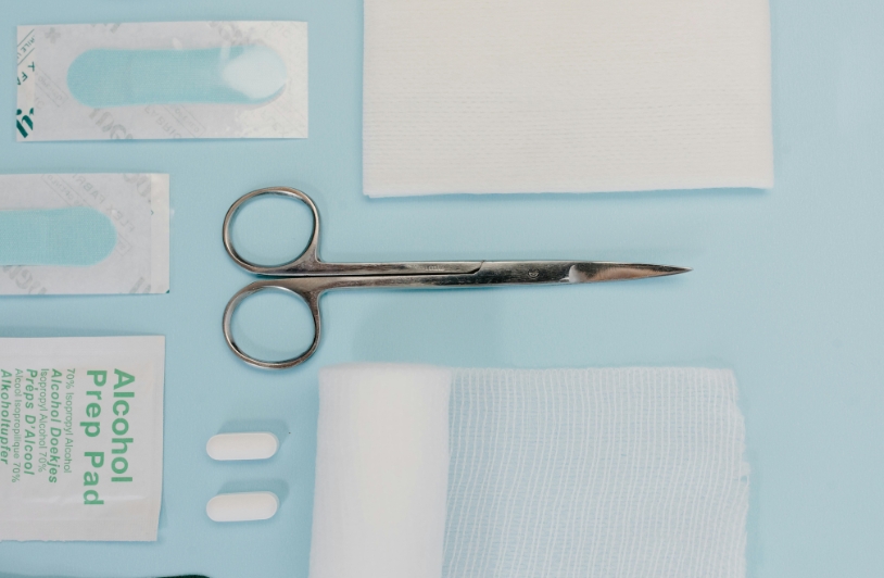 Scissors and other medical supplies on blue background.