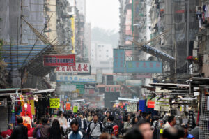 Crowded Chinese street market with shops and signs.