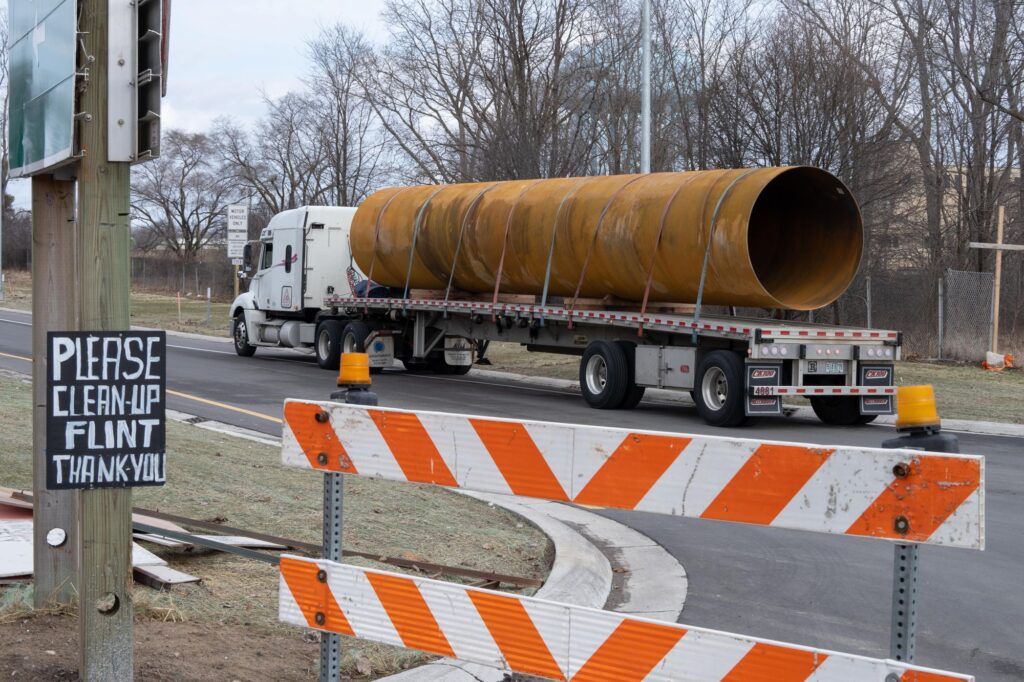 Flint, Michigan: Pipe Politics Large water main pipe on truck in Flint