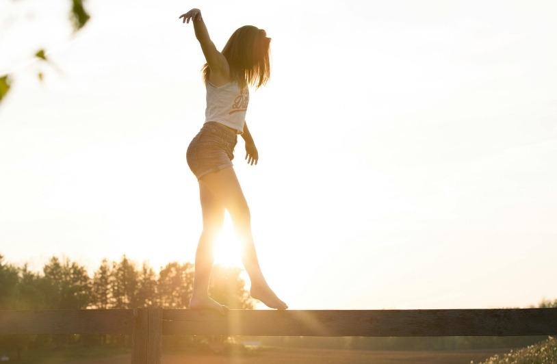 Girl balancing on tree log.
