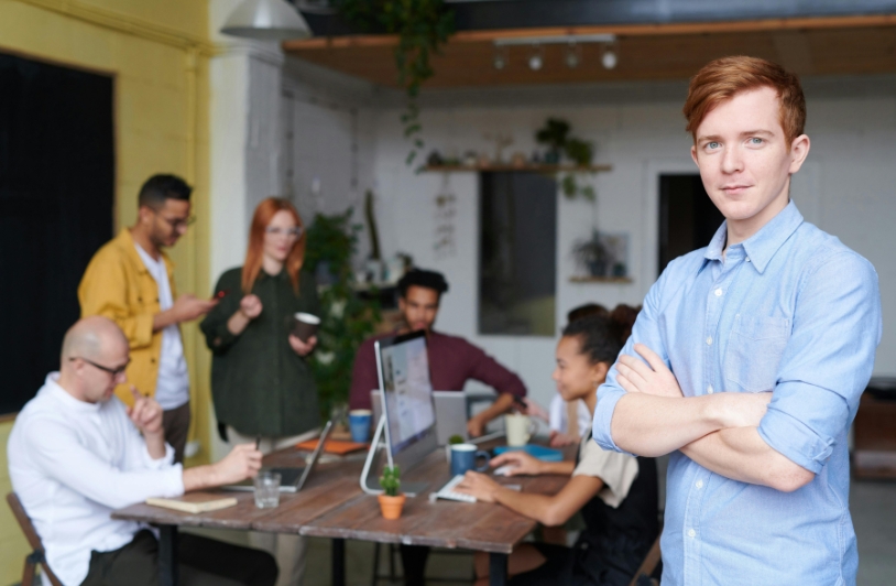 Young business man in front of small team.