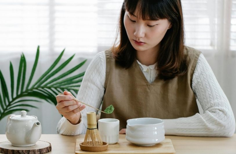Woman Sitting and Making Matcha Drink