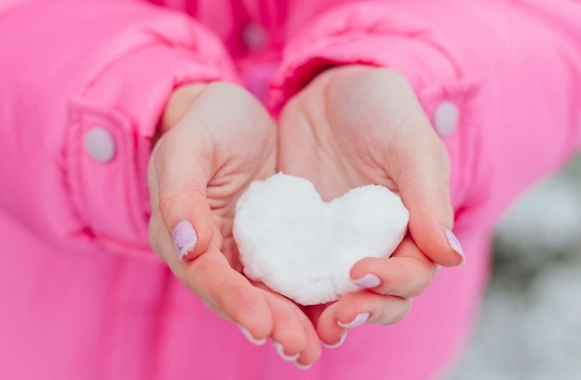 A woman holding a heart in her hands.