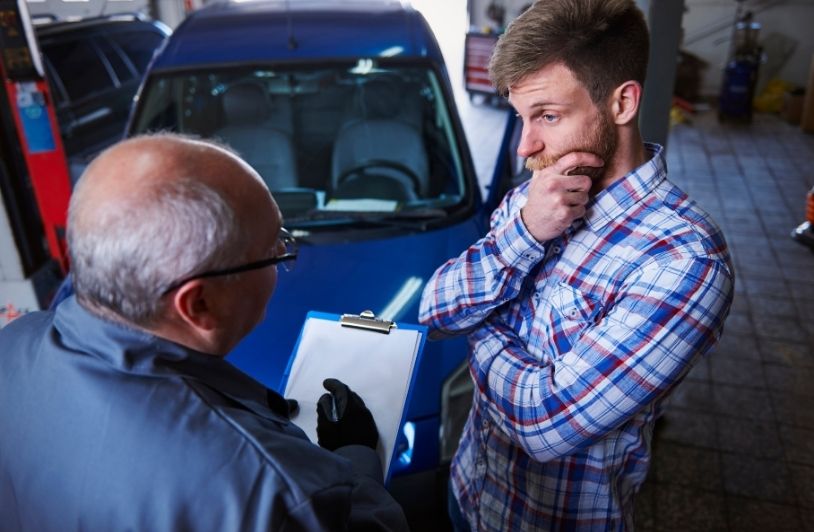 Customer talking with a mechanic in the workshop