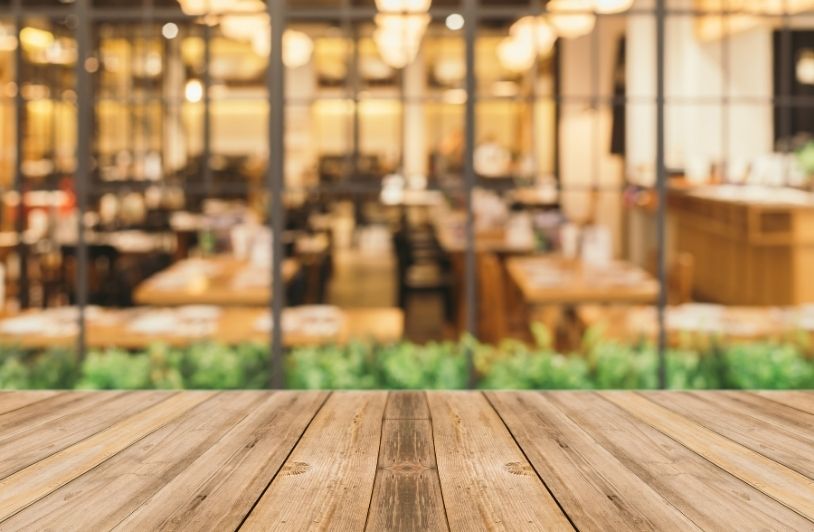 Economic Shifts and Restaurant Design: Why Tables Tell a Story Wooden planks with blurred restaurant background