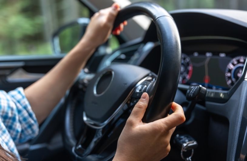 Hands on steering wheel of modern car during trip control and confidence on the road