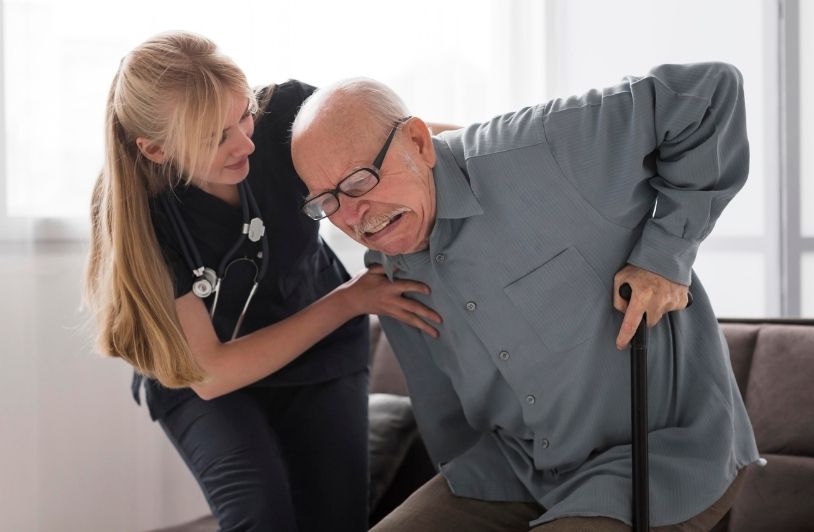 Old man in pain helped by nurse
