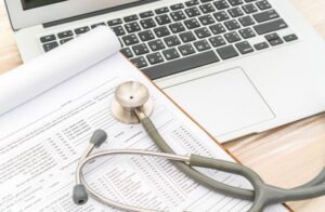 Stethoscope and prescription on laptop