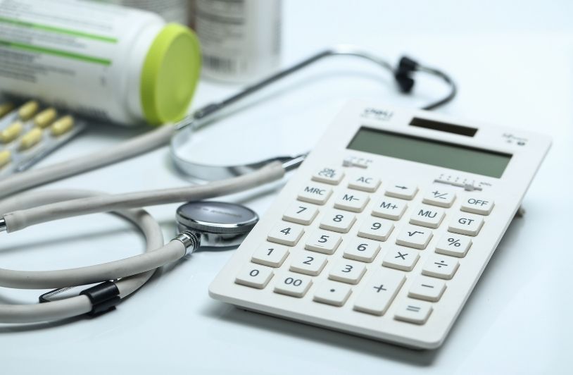 How Your Medical Bills Get Paid After a Crash Calculator, stethoscope and medicine bottles on white background