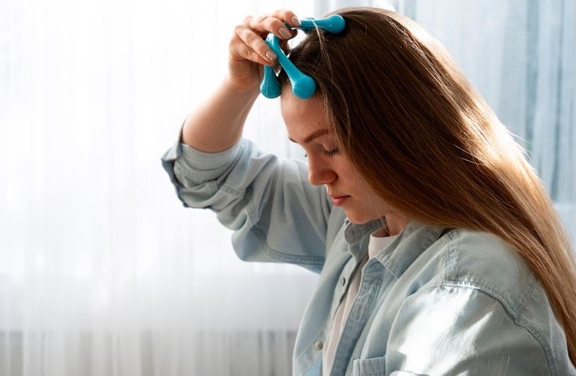 Woman giving herself scalp massage