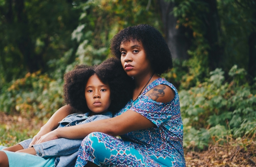 Black mother and daughter in forest