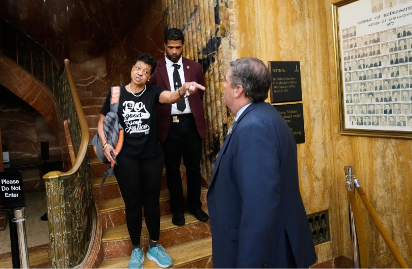 black woman on stairs pointing at man