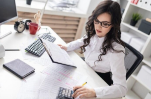 Woman at desk on calculator
