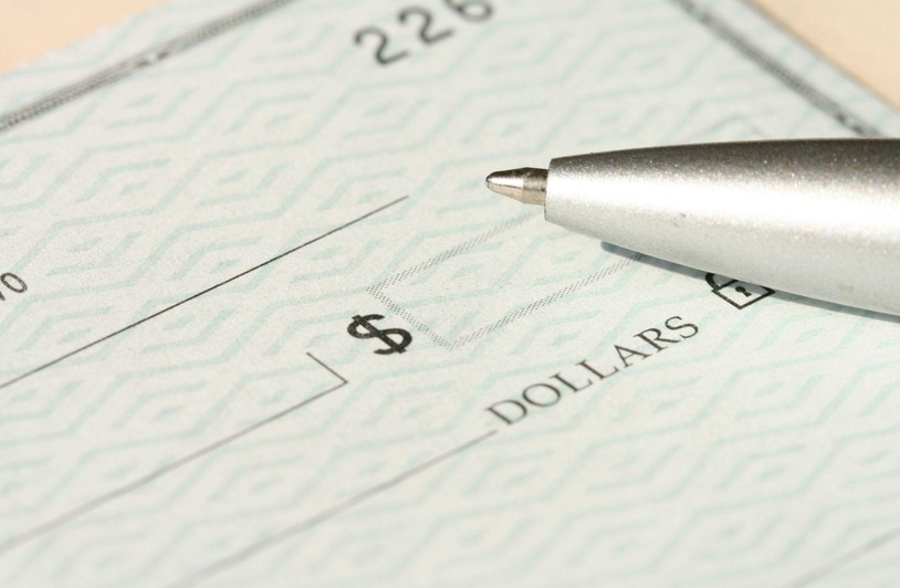 Why More Companies Are Tightening Internal Payroll Verification Processes Pen signing check.