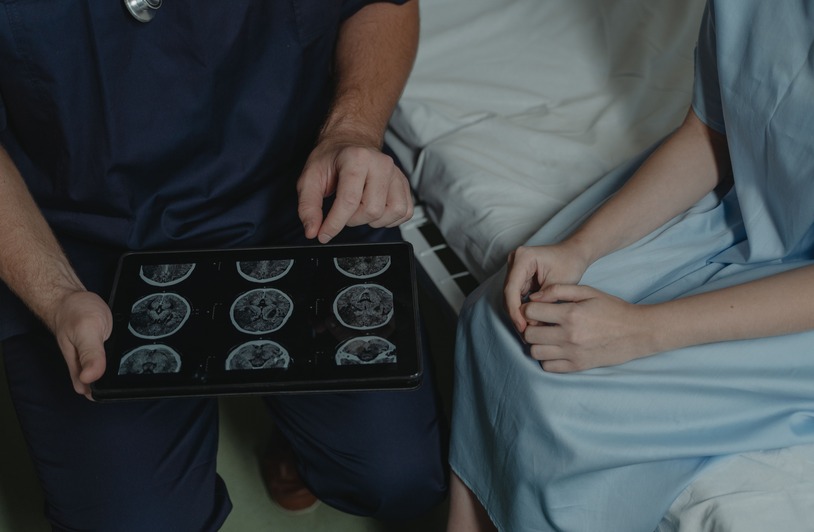 Medical professional reviewing a brain scan on a lightboard in a clinical setting