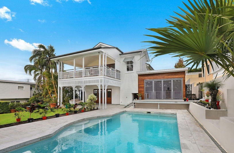 What Makes a House Feel Like a Retreat – and Sell Faster Because of It A bright, warmly lit living room with natural wood accents, soft textiles, and indoor plants creating a calm retreat atmosphere
