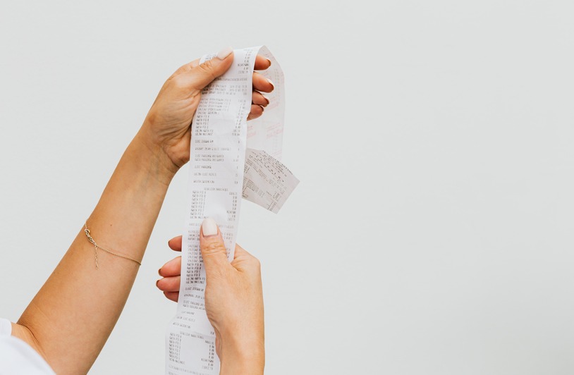 Policy Choices and Household Stability: Inflation, Rates, and Work Person reviewing grocery receipt and household bills at a kitchen table