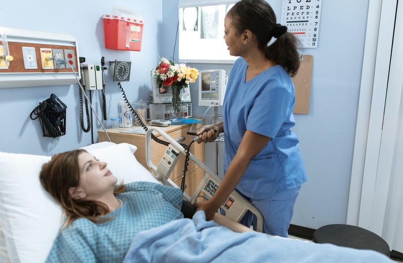 Understanding the Nursing Shortage: Causes, Impact, and Career Opportunities A nurse in scrubs reviewing patient information in a hospital corridor