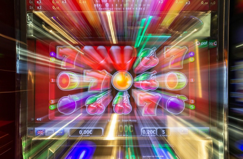 How Regulation Has Changed the Online Casino Industry A person using a laptop in a dimly lit setting with casino-style lighting in the background
