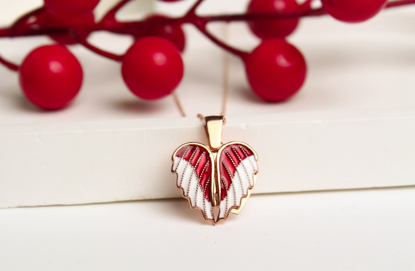 14K Gold Penguin Heart Pendant Necklace Conveys Love and Loyalty Stylish heart-shaped pendant with intricate design, highlighted against vibrant red berries. Perfect for fashion and lifestyle themes.
