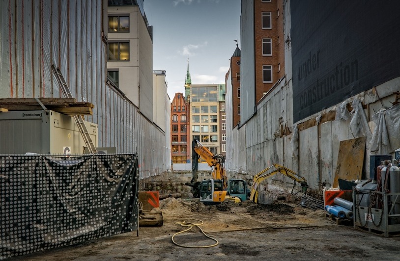 Choosing Industrial Equipment That Holds Up Under Constant Outdoor Use Construction site in an urban area with excavators and scaffolding, showcasing development.
