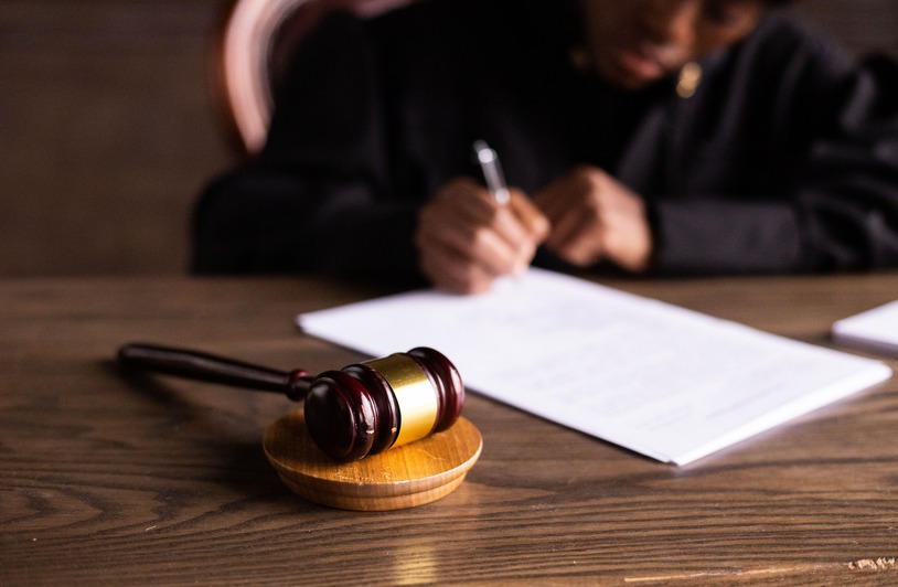 A lawyer and client seated at a courtroom table reviewing legal documents