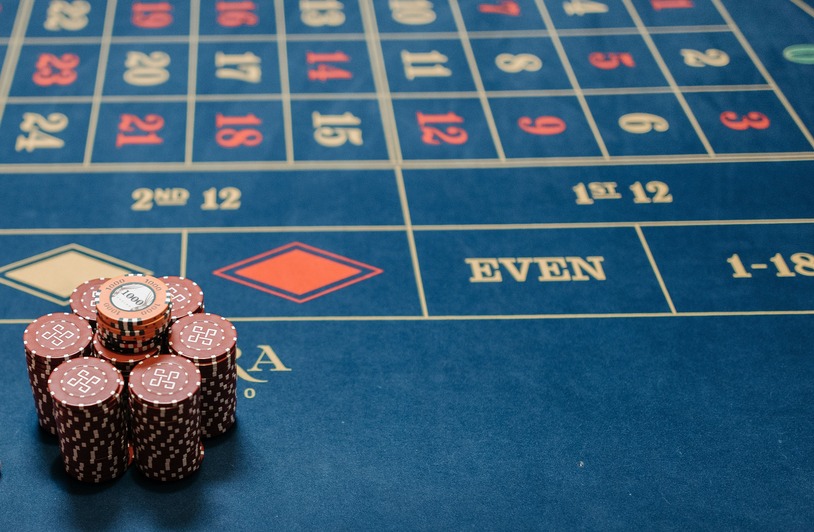A Section-by-Section Walkthrough of Crown Casino Online Stacks of dark red casino chips on a blue roulette betting table with numbered grid and betting zone labels