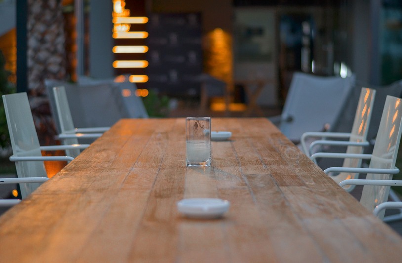 Economic Shifts and Restaurant Design: Why Tables Tell a Story Rustic wooden table in an outdoor cafe setting with evening lights and modern decor.