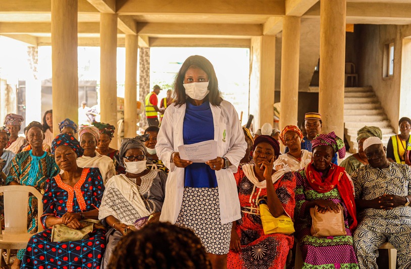 Empowering Communities Through Advanced Health Education A female doctor giving a health lecture to a group of senior women indoors.