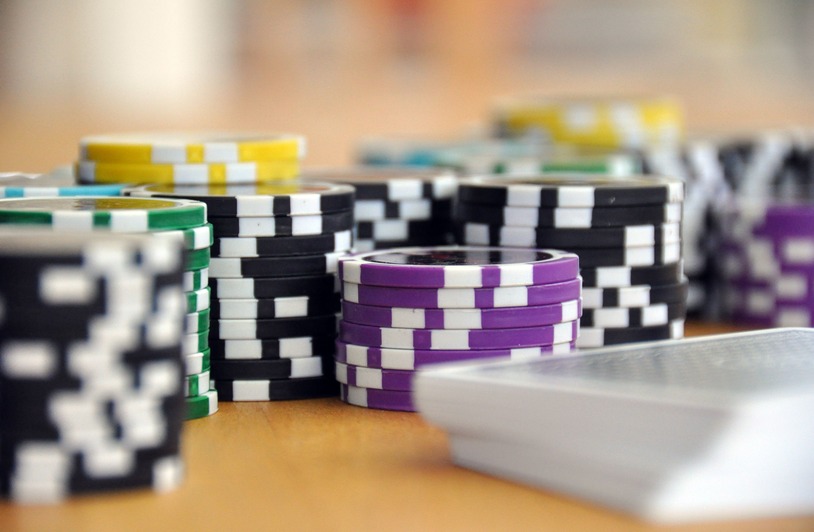 Exploring the Benefits of Licensed and Regulated Online Casinos: Why Responsible Gambling Starts with Choosing the Right Platforms A close-up shot of stacked poker chips and playing cards on a table, perfect for casino and gambling themes.