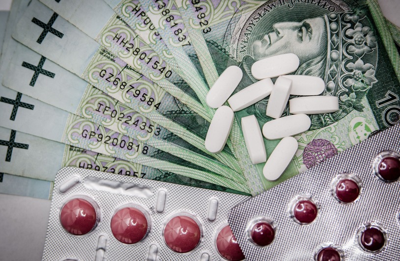 How Your Medical Bills Get Paid After a Crash Polish 100 złoty notes with pills and blister packs, illustrating medical costs.