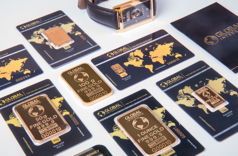 Understanding the Live Gold Price: What Investors Should Know Several gold bars in black Global Intergold branded packaging cards arranged on a white surface beside a gold-toned wristwatch